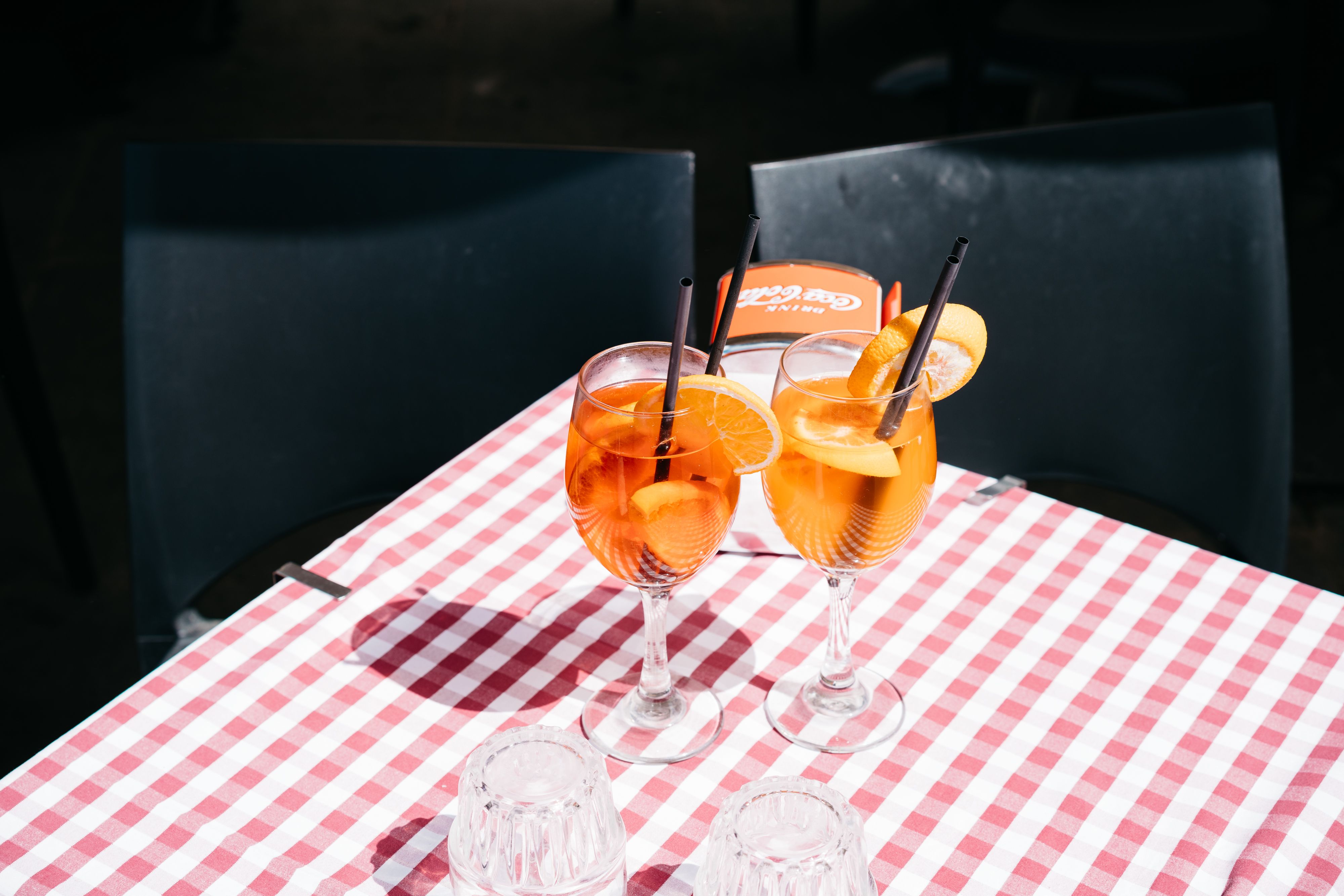 Twee Italiaanse aperitivo spritz-cocktails op een geruit tafelkleed